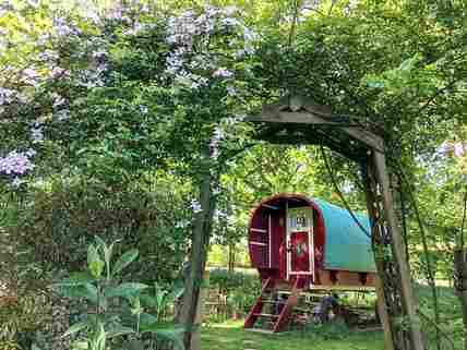 Walk through the archway of roses and clematis to the grassy area outside the pretty gypsy van
