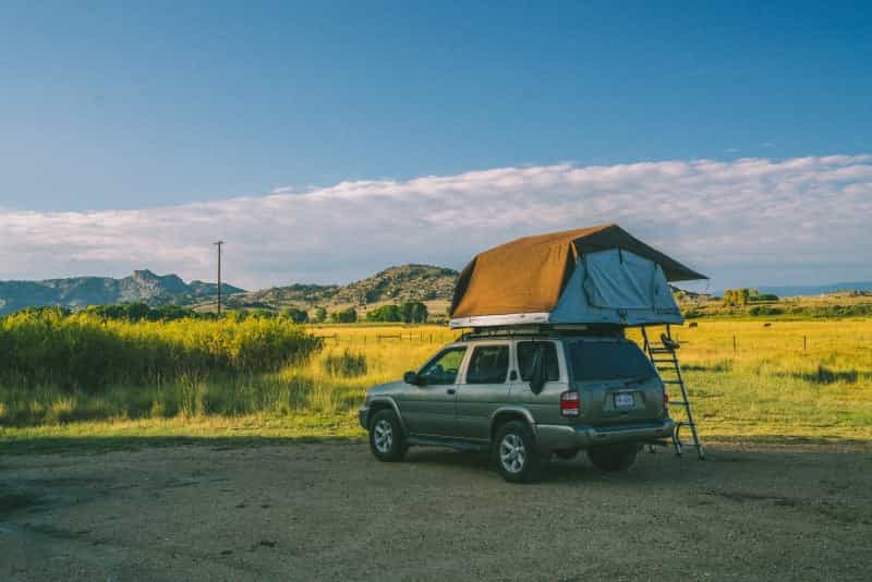 A soft shell rooftop tent out on the open road (Michael Aleo / Unsplash)
