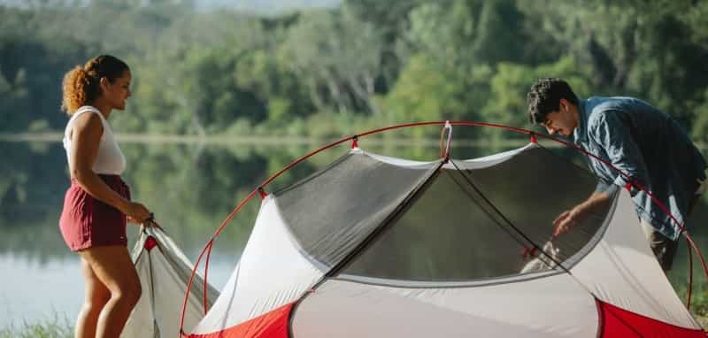 A couple handle the tent’s flysheet (Uriel Mont / Pexels)