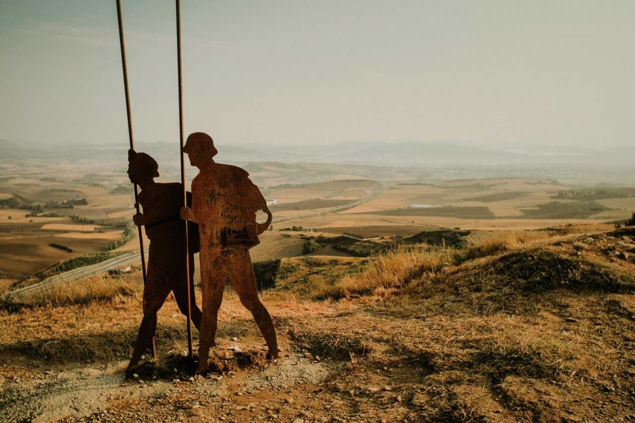 Sculpture of Camino pilgrims walking with sticks (Kamil Szumotalski / Unsplash)