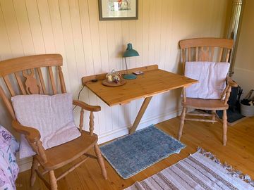 Shepherd's hut with a fold-down table, two carver chairs and hobbit woodburner (added by manager 11 aug 2021)