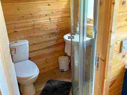 Small bathroom with toilet, sink and hot shower.