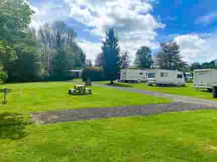 Spacious hardstanding pitch with room for an awning on grass and car parking space