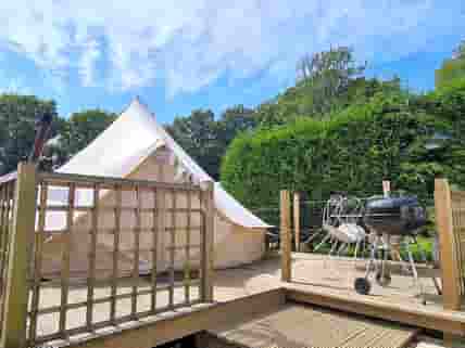 The bell tent has a deck with barbeque and seating.