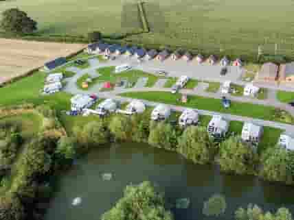 Aerial view of the pitches, the pods and one of the lakes on site