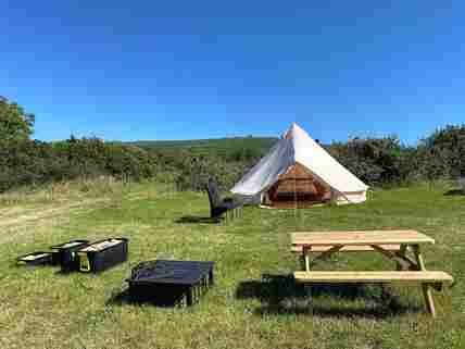 Bell tent pitch with picnic table and firepit