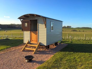 Cosy Shepherd's Hut with Double bed, heating, kitchen/dinning area & outdoor seating.