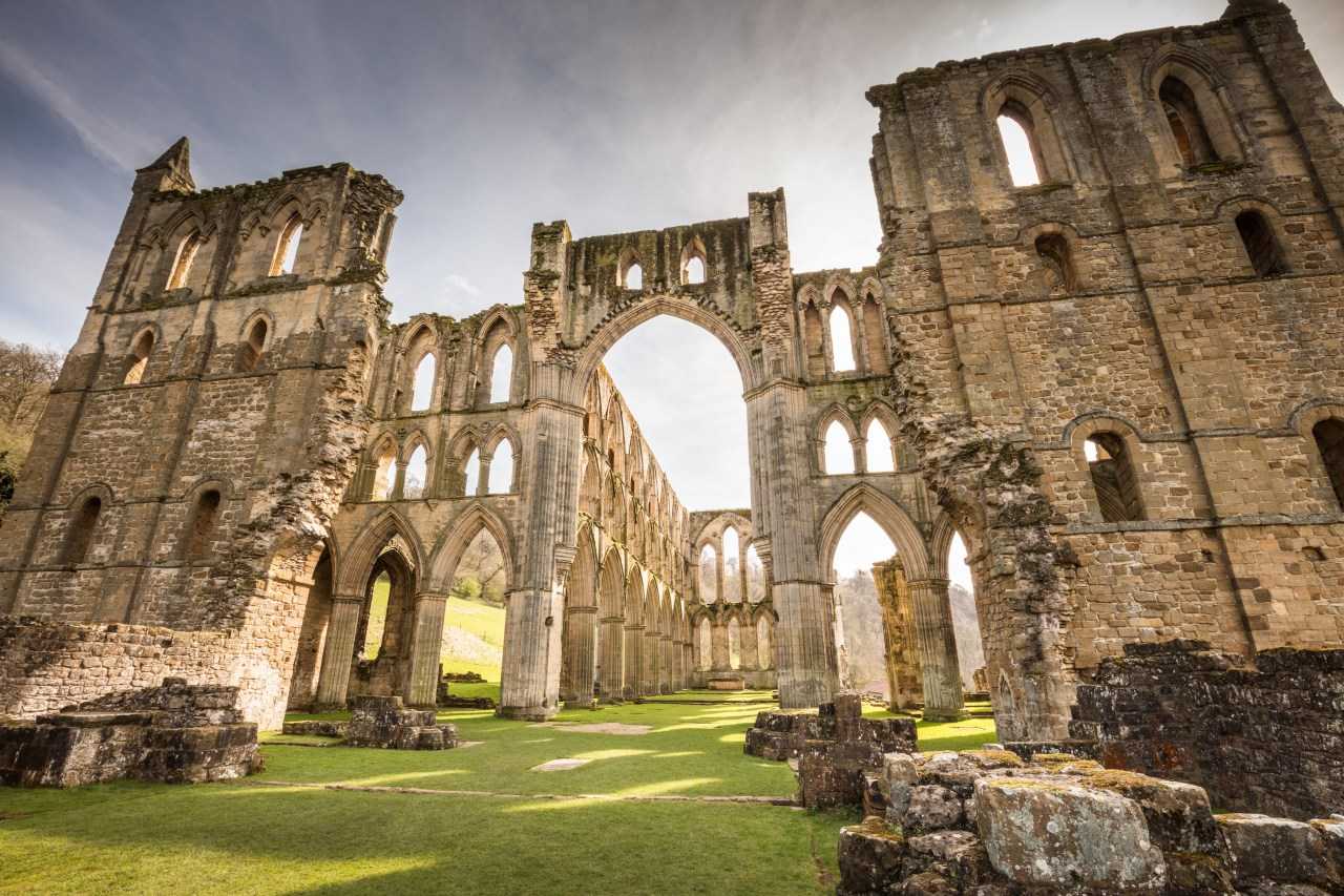 Light streaming through the ruined arches of Rievaulx Abbey (Michael D Beckwith on Unsplash)