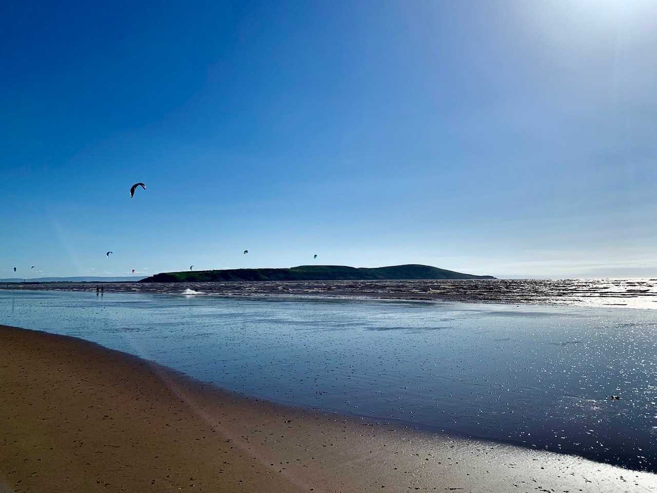 Kitesurfers fly above the water on Weston-super-Mare's beach