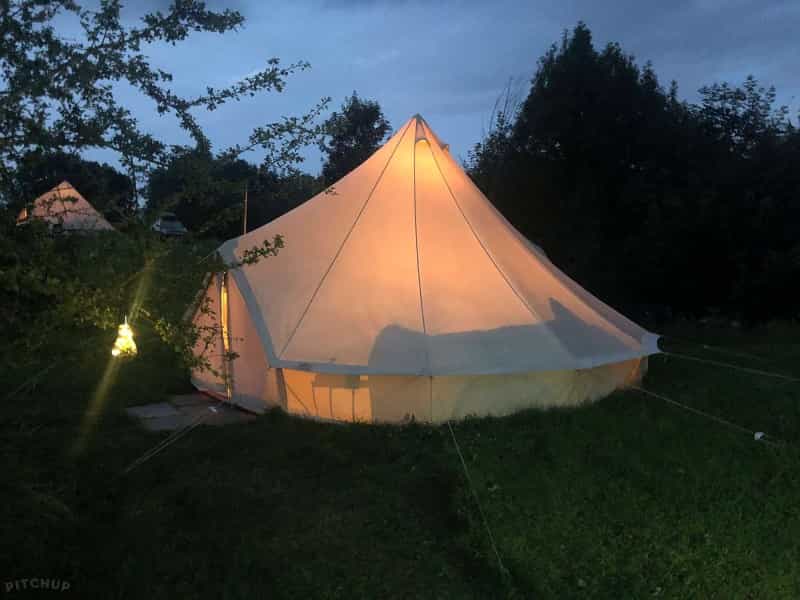 A bell tent lit up at night