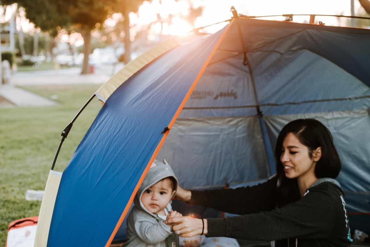 A family with a young child camp out in a tent (Omar Lopez / Unsplash)